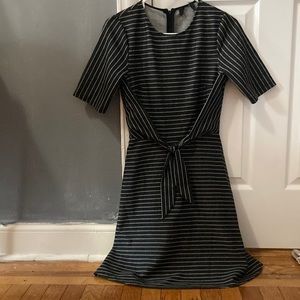 Black a-line dress with thin, white stripes and a bow